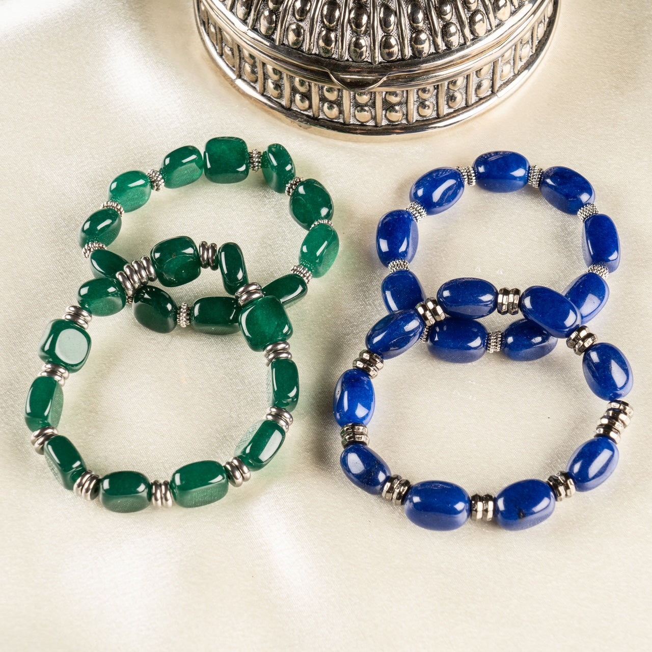 Stackable green jade and deep blue lapis lazuli gemstone bracelets with silver spacers.