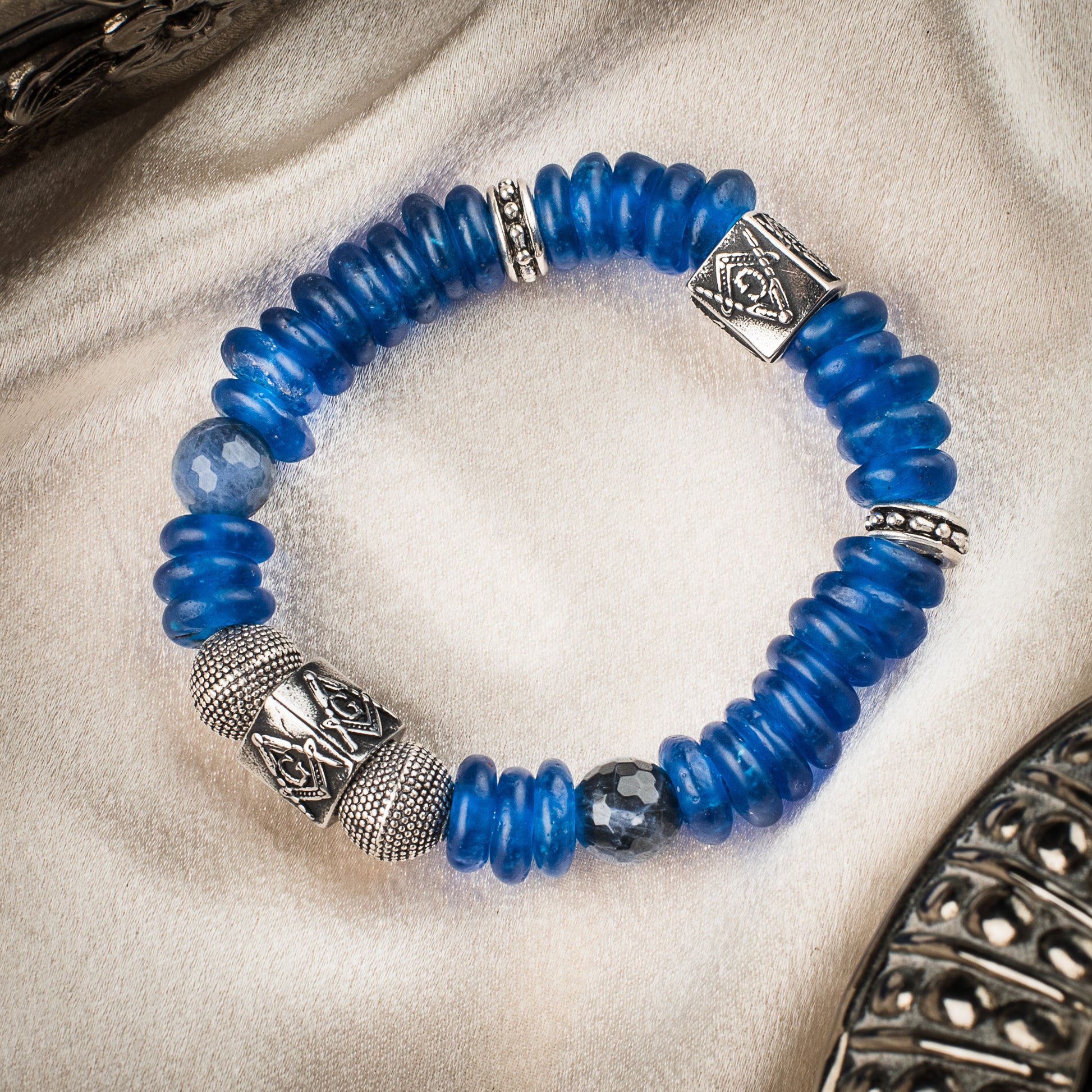Blue beaded stretch bracelet featuring silver-tone Masonic Square and Compasses charms.